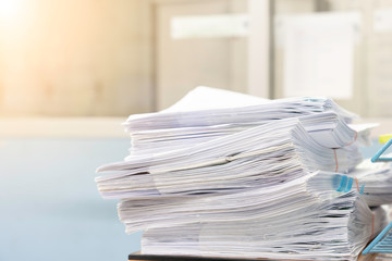 Stacks of paper files work desk office, business report papers,piles of unfinished documents, Business concept.