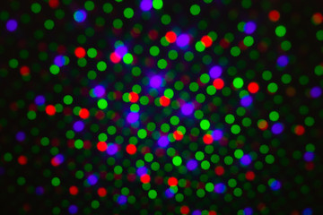 Abstract dot defocus background backdrop, rainbow colored green red violet round glitter on black background. Illumination blurry lights, abstract light spots