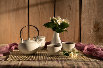 The tea in a cup and a bouquet of jasmine on a table close-up