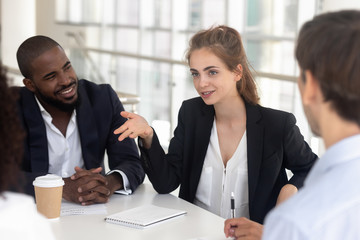 Female employee talk discussing ideas with colleagues at meeting