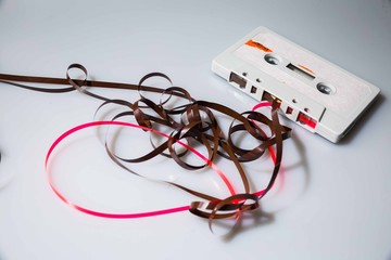 Leeds, UK, 03/02/19Cassette unspooled with loose tape tangled up around itself shot on isolated on a white background professionally with studio lighting and old retro vintage media unused now