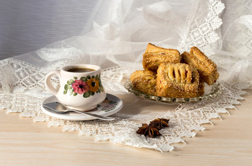 Cup with coffee and cakes with fillings on the table close-up