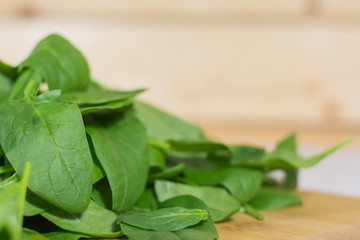 зеленыые листья шпината лежат на деревянном столе. Здоровая пища