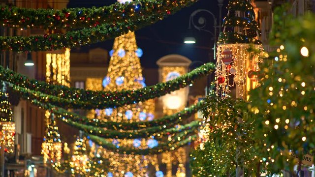 Christmas tree with decoration light and Christmas street illumination in the city during Christmas and New Year Holidays. Blured background. UHD, 4K