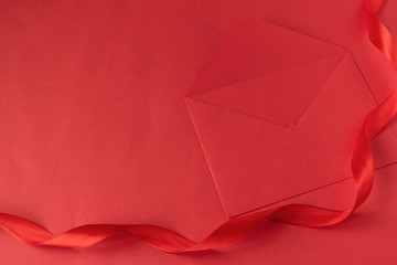 Red envelope with a satin ribbon on a red background. Valentine's day for Valentine's Day. Love..