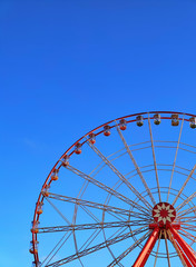 Part of Ferris wheel with clear blue sky