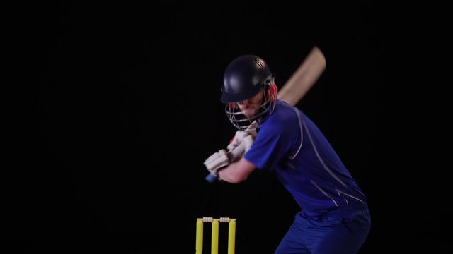 4K: Cricket Batsman hitting the ball - Cut shot. Black background. Dressed in blue. TwentyTwenty - Stock 4K Video Clip Footage