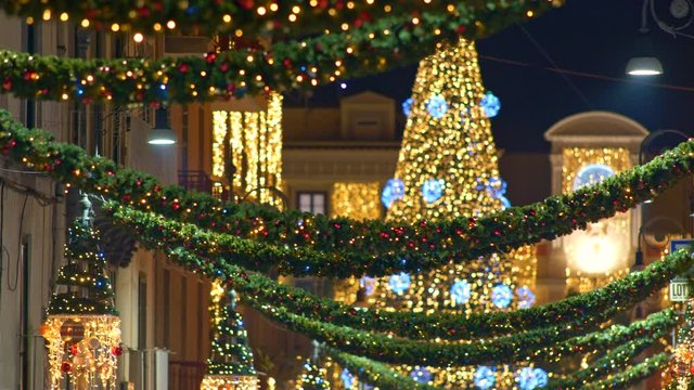Panning shot of Christmas tree with decoration light and Christmas street illumination in the city during Christmas and New Year Holidays