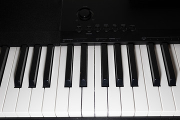 A fragment of an electric piano with black and white keys.