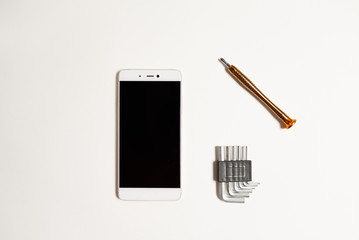 Repair of a cell phone in the service with a special tool. Cell phone repair tool on a white background.