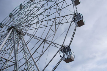Ferris wheel in Kirov. Modern attraction. White construction. Cloudy weather.