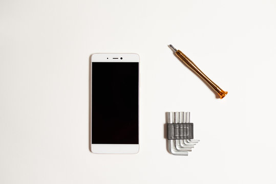 Repair of a cell phone in the service with a special tool. Cell phone repair tool on a white background.