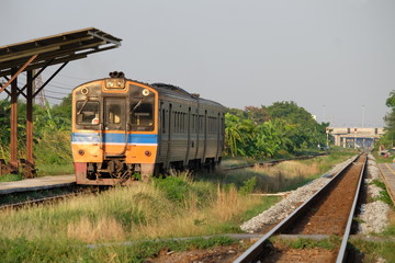 Fototapeta premium Pociąg jeździ po szynach na przedmieściach. Trasy kolejowe od dawna służą towarom i ludziom i są nadal popularne.