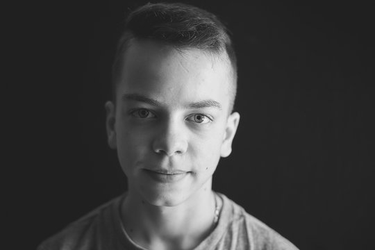 black and white portrait of a teenage boy on a black background