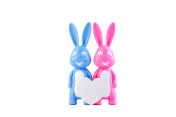 Cute bunnies as happy lovers couple with heart on white background isolated, creative Valentine's day card, family love and dating concept.Easter banner, wallpaper.Pink and blue rabbits.Minimal style.