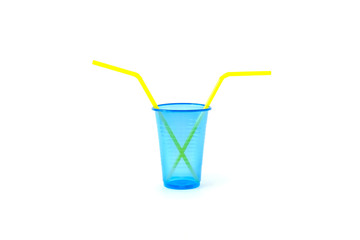 Blue empty disposable plastic glass with yellow drinking straws isolated on a white background.