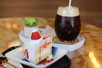 Strawberry cake with black coffee in coffee cafe and restaurant