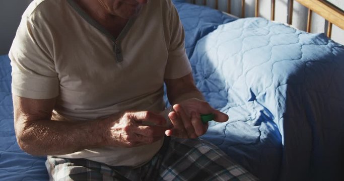 Senior man with medical drugs at home