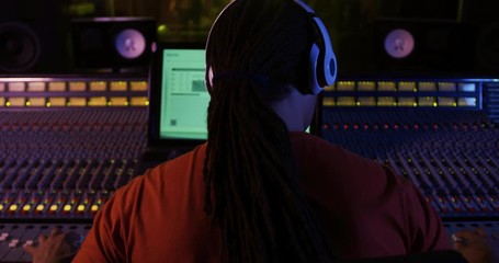 Male sound engineer working at a mixing desk - Powered by Adobe