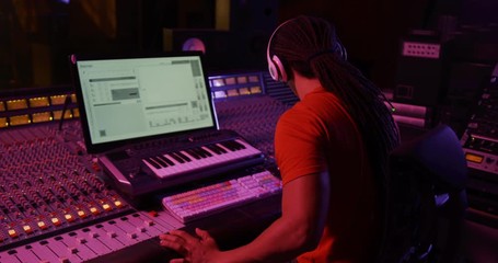 Male sound engineer working at a mixing desk - Powered by Adobe