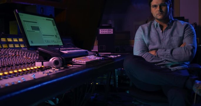 Male sound engineer sitting at a mixing desk
