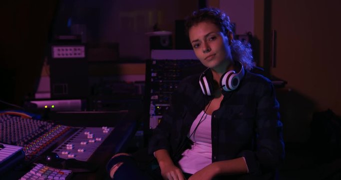 Female sound engineer sitting at a mixing desk