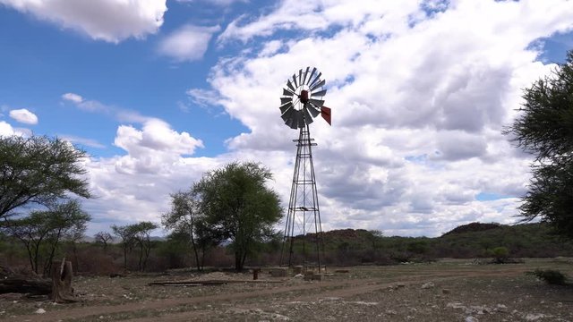Still stable shot of a windpump blowing in the wind on a farm in Namibia on a cloudy sunny day.