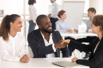 Happy diverse couple handshake female specialist greeting at meeting