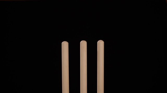 Cricket Wickets bowled out - The stumps are hit with the White ball. Black background. - Stock 4K Video Clip Footage