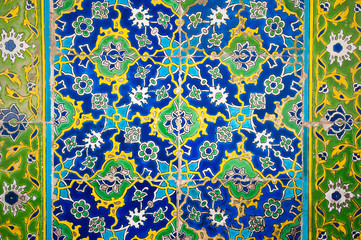 Medieval era glazed tile wall of intricate green and blue floral patterns in a Turkish Islamic mosque in Istanbul, Turkey dating back to 1459
