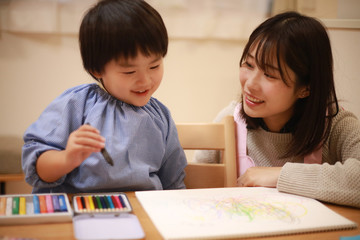 お絵描きする男の子と保育士イメージ