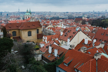 Obraz premium Panoramic view of Prague, the capital of the Czech Republic, and the Vltava river, traditional red rooftops from one of the Prague hills in late autumn