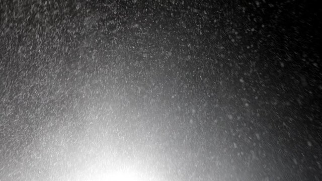 Real snow falling in the rays of street lights. Winter concept. 4K
