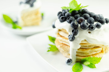 Delicious pancakes with sweet creamy yogurt and fresh berries with mint