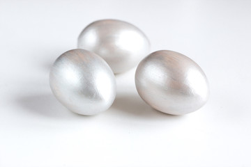 Easter holiday composition. Three eggs of silver color on a white background. Easter flat ley. Easter concept. Copyspace.