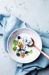 Healthy breakfast - yoghurt with blueberries and walnuts