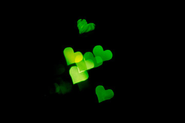 Abstract light, green bokeh pattern in heart shape. St Valentines Day or Holiday concept, background image.