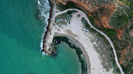 Luchtfoto top-down mening van Bolata Cove op de Zwarte Zee, Bulgarije. Wit zandstrand aan de kust in de buurt van Kaap Kaliakra. Stenen, schuimende golven, zonnebadende mensen en kleurrijke bootjes van bovenaf.