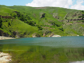 Panorama of a mountain lake with beautiful blue or turquoise colored water