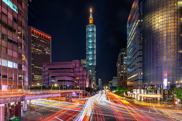 Fototapeta na wymiar Traffic speeds through an intersection at night in Taiwan.
