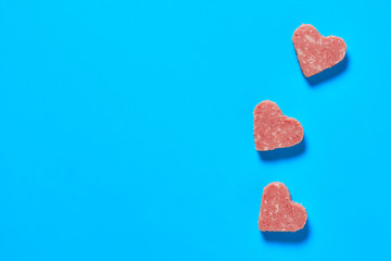 Three pieces of sausage in form of heart. Valentines day concept. Space for text. Top view
