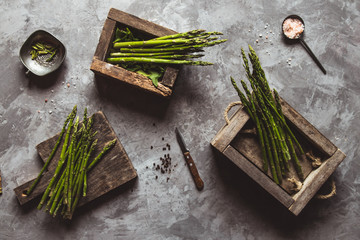 Asparagus on a cutting board in a wooden box. Healthy food, health on a concrete background.