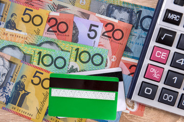 Cash and credit card. Colorful australian dollar banknotes with plastic banking card and calculator on table. Financial system