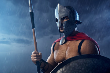 Wet spartan warrior holding spear and shield.