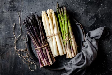 Poster Bunches of fresh green, purple, white asparagus on vintage metal tray over dark grey rustic background. Top view, copy space © sveta_zarzamora