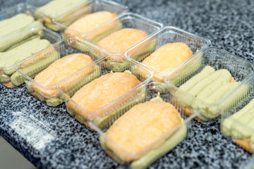 Colorful and delicious pistachio dessert in plastic package on table in factory. Food industrial manufacturing.