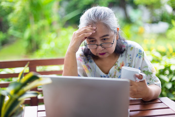 Senior woman seriously with laptop computer at home