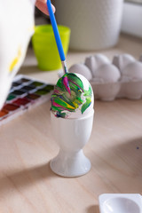 Toddler boy painting easter eggs preparing for holidays. Close up of kids hands. Easter tradition