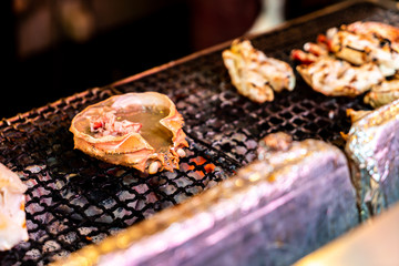 grilled crab shell with miso called Kani Miso Koura Yaki on a hot grill