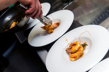 chef puts sauce on a shrimp cocktail in a restaurant, the finished dish